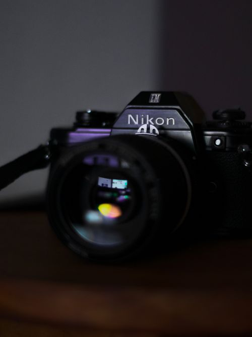 Free Close-up of a vintage Nikon camera lens with colorful reflections, captured with selective focus. Stock Photo