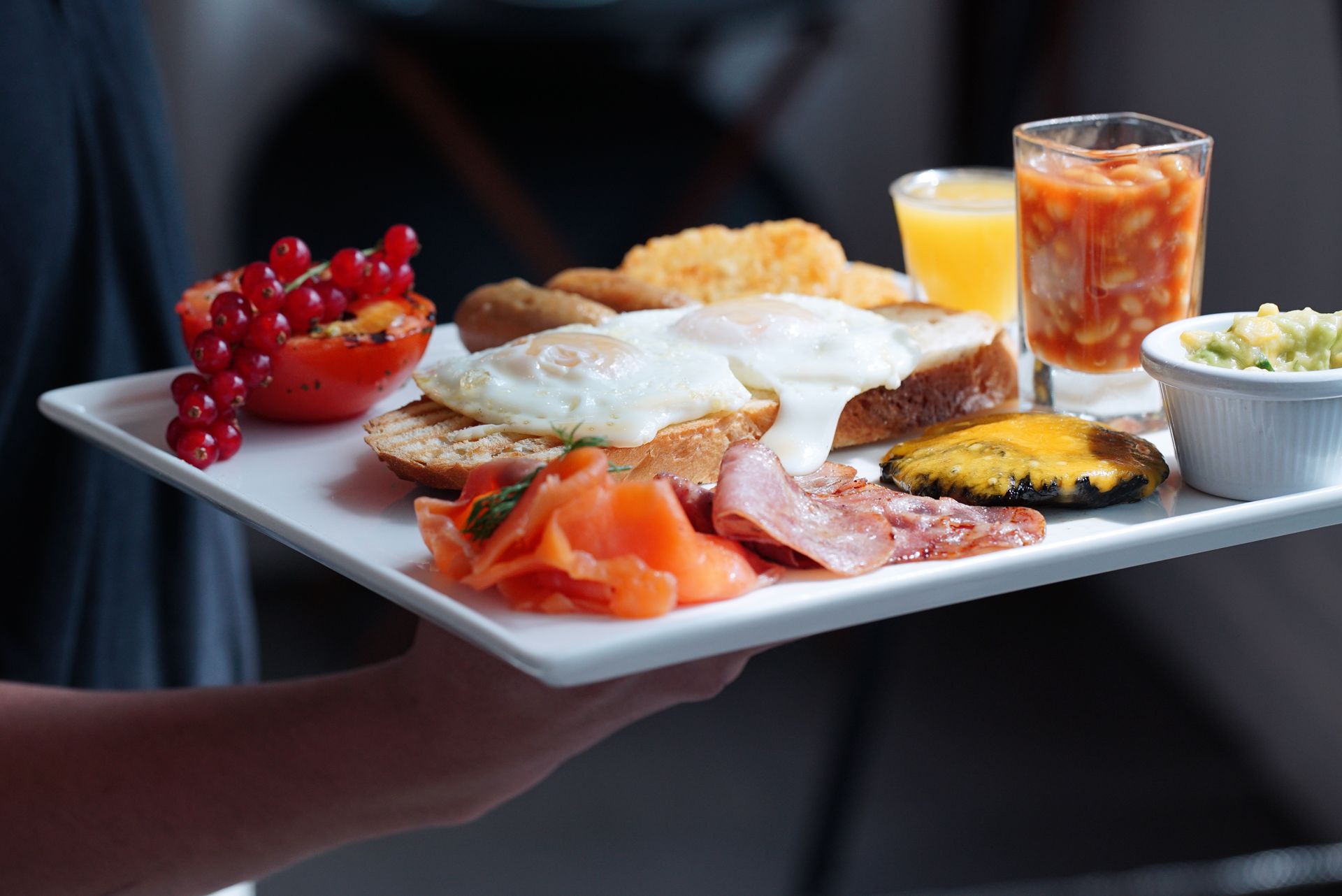 Delicious gourmet breakfast tray featuring eggs, toast, salmon, and more, served at a Dubai restaurant.