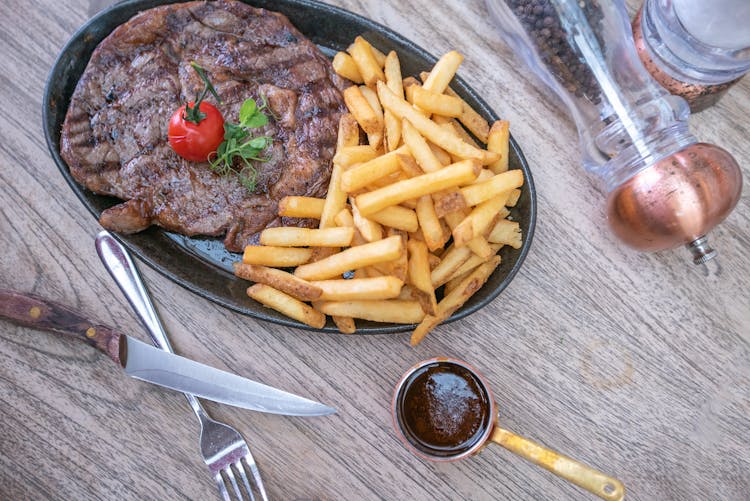 Grilled Steak With Fries On Oval Plate