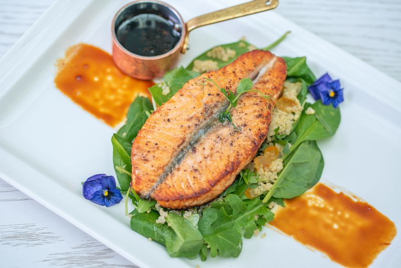 Seared salmon fillet over greens and grains — photo by Denys Gromov on Pexels