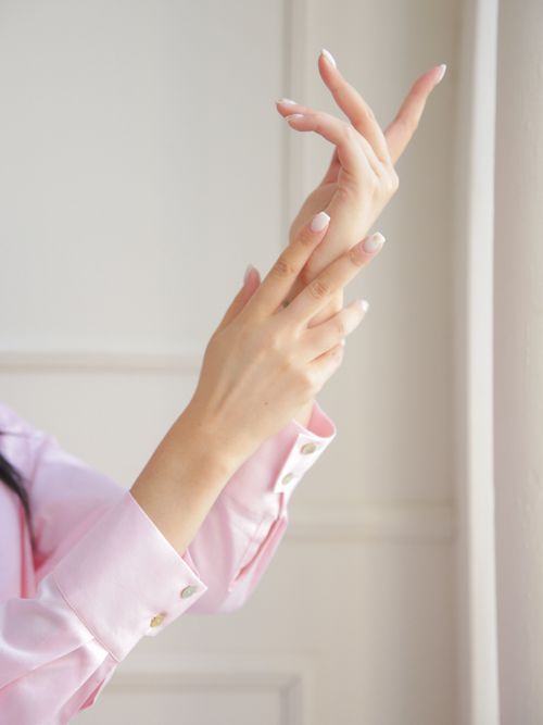 Free Elegant female hands with manicured nails in graceful pose against soft natural light background. Stock Photo