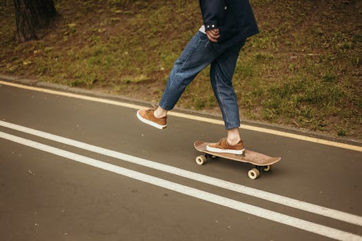 A person skateboarding on a pathway surrounded by grass, depicting outdoor activity.
