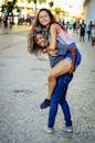 Women Piggyback on City Street