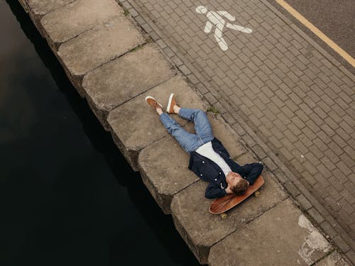 Photo of Man Lying on Concrete Floor