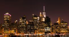 纽约市的夜景照亮了天际线，展现出标志性的摩天大楼和城市灯火