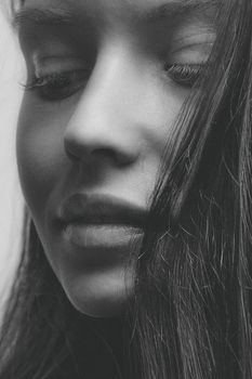 Close-up grayscale portrait of a woman with a serene and pensive expression.