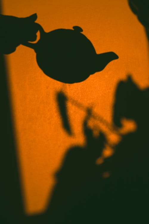 Silhouette of Person Holding A Teapot