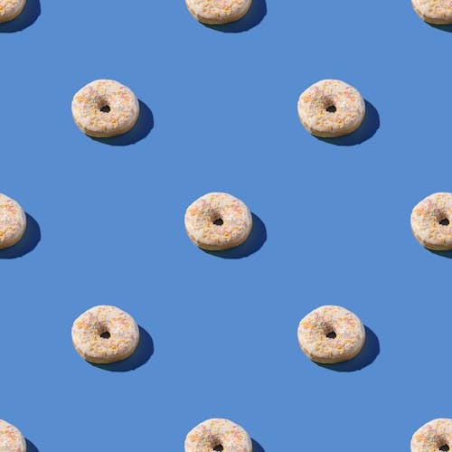 Doughnuts With Sprinkles On Blue Surface