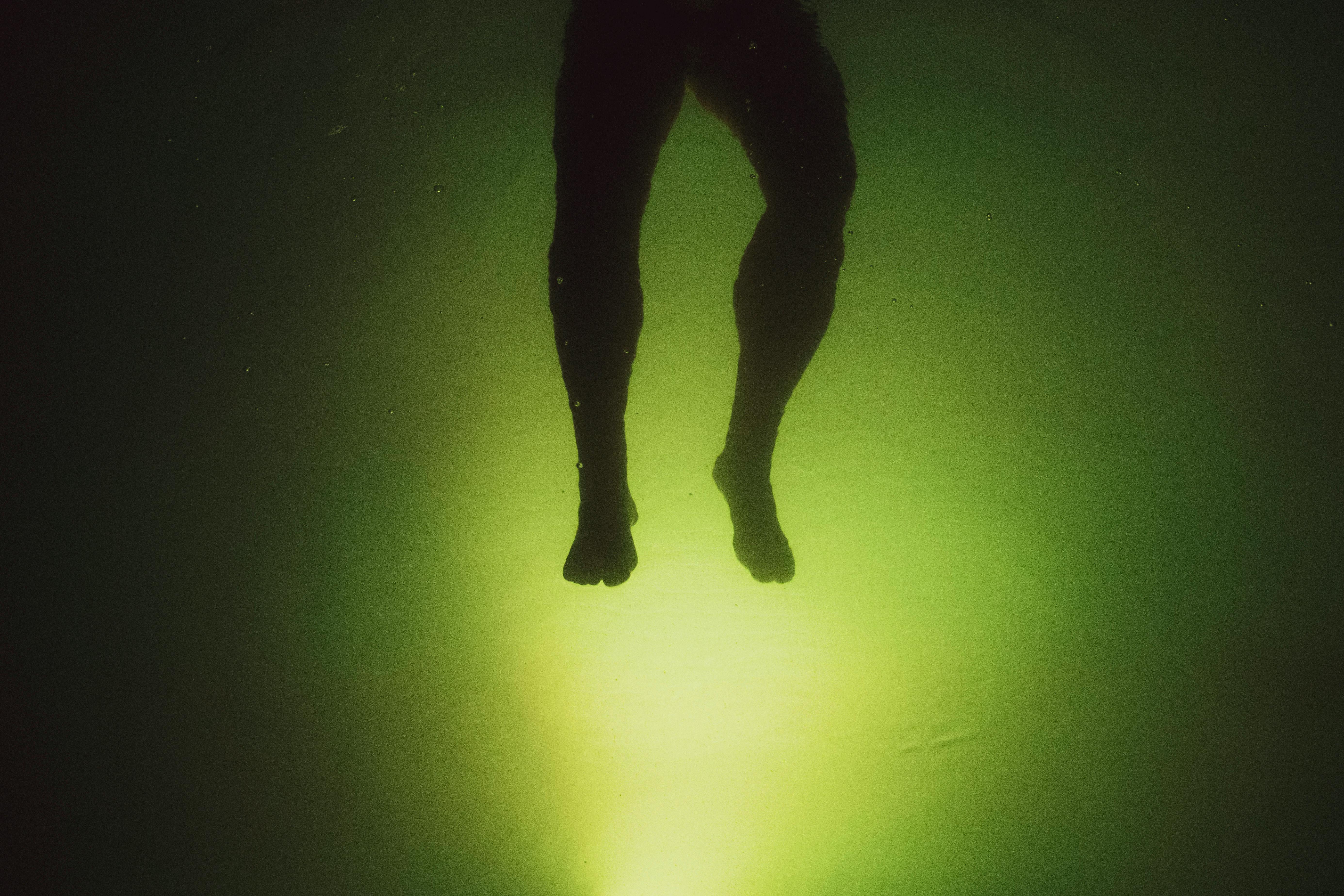 anonymous man swimming in water near green background