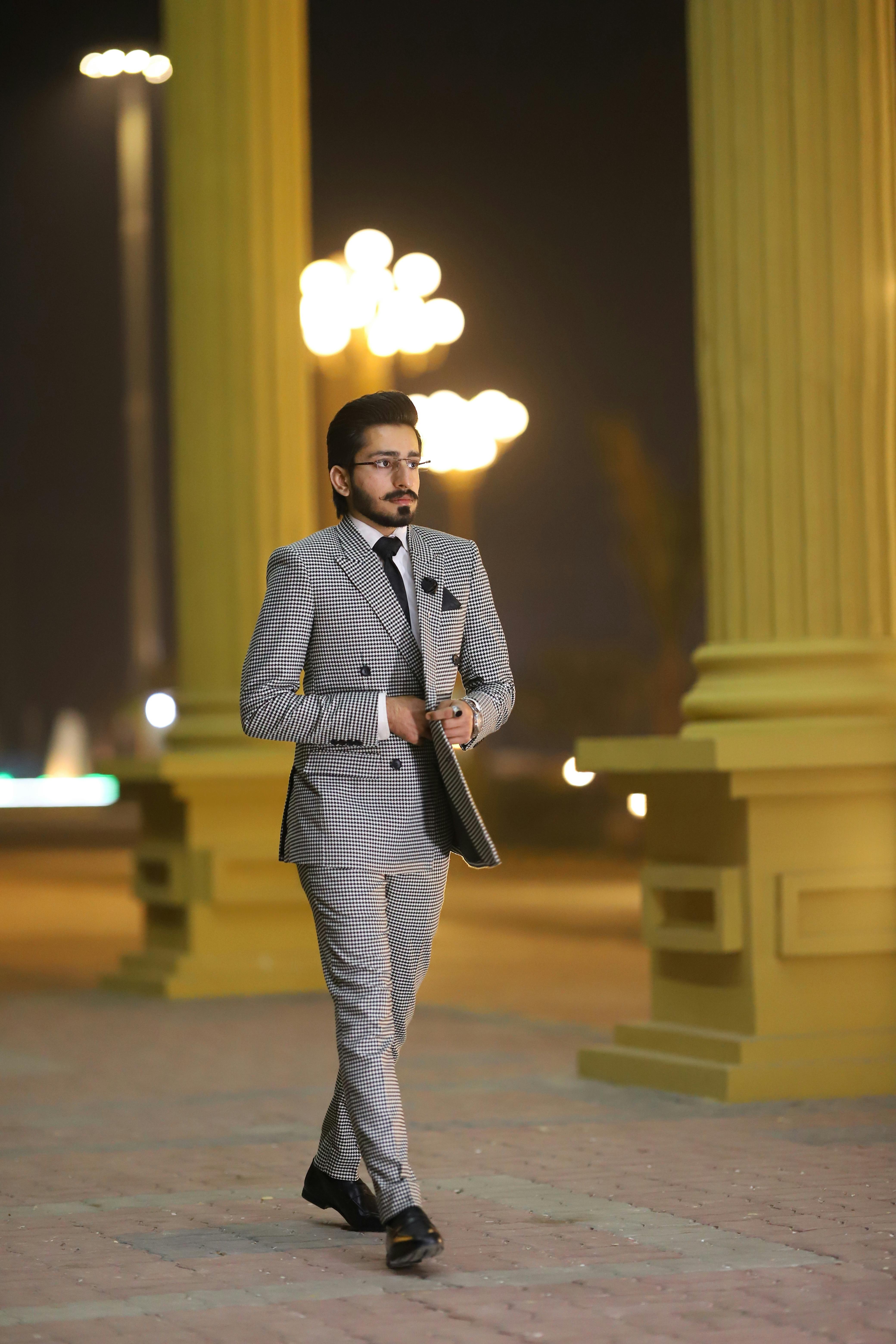 photo of man walking in grey suit