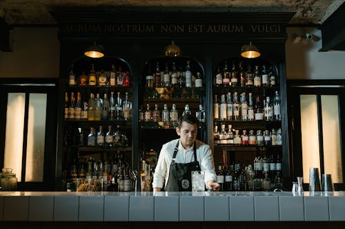 Man in White Dress Shirt Standing in Front of Counter