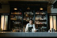 Man in White Dress Shirt Standing in Front of Counter