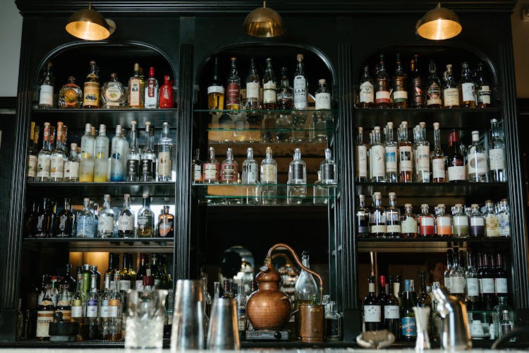 Clear Glass Bottles On Brown Wooden Shelf