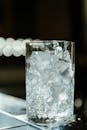 酒吧柜台上，优雅的水晶玻璃杯里装满了冰块，背景一片模糊