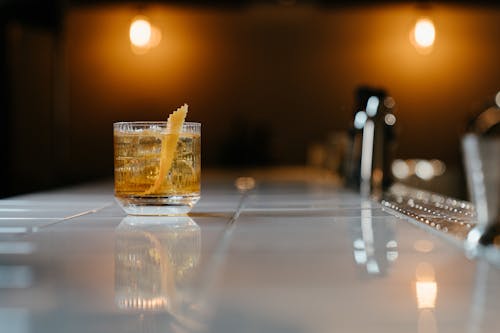 бесплатная Прозрачный стакан для питья с желтой жидкостью на столе Стоковое фото