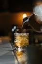 Person Holding Clear Drinking Glass With Brown Liquid