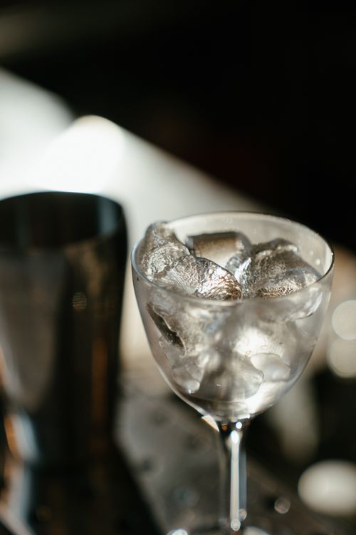 Free A wine glass filled with ice cubes on a bar table, with blurred background and copy space. Stock Photo
