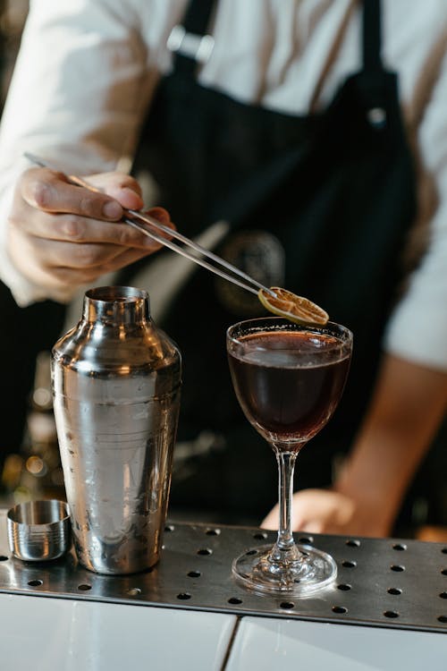 Orang Menuangkan Cairan Coklat Pada Gelas Minum Bening