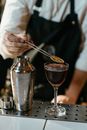 Person Pouring Brown Liquid on Clear Drinking Glass