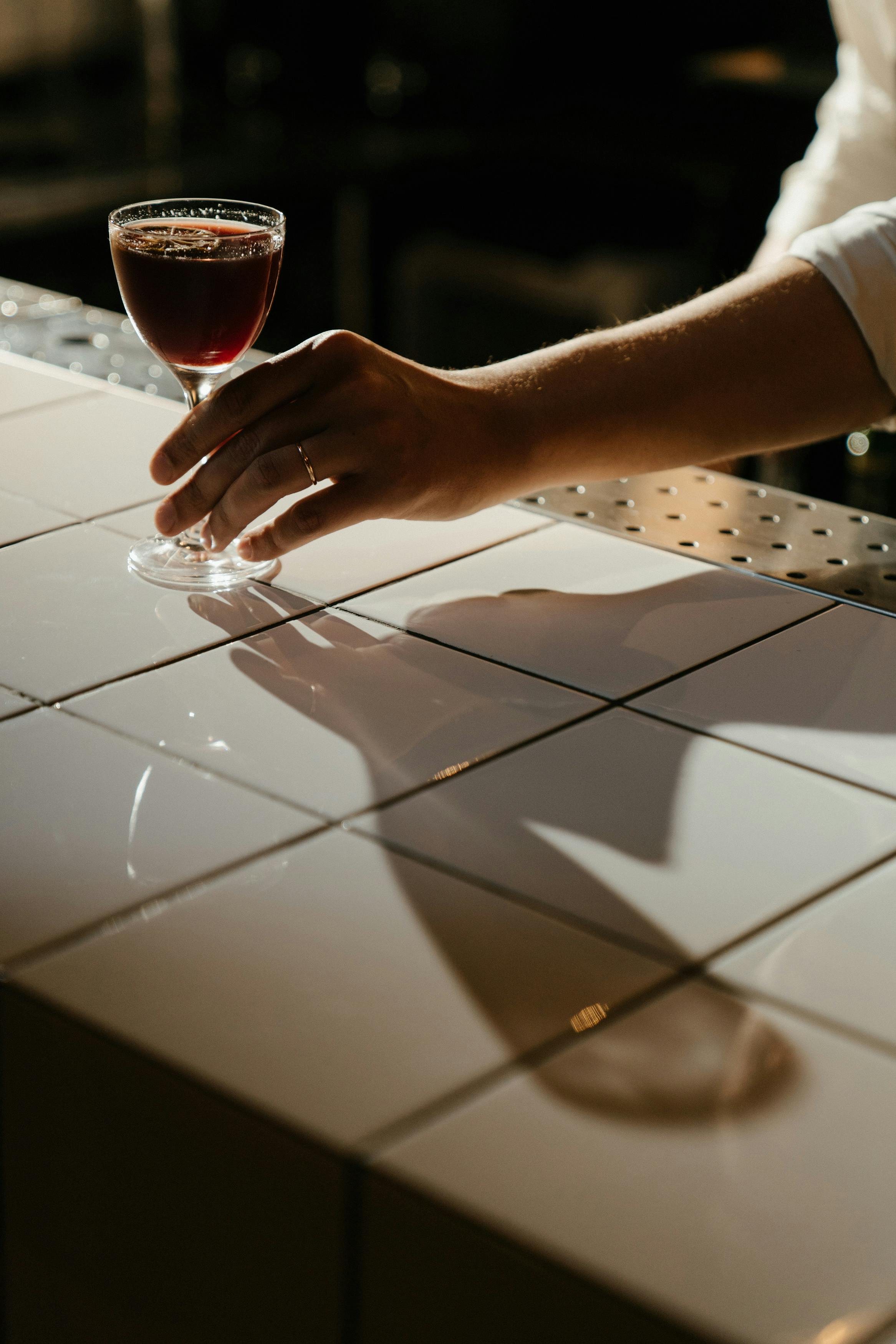 Clear drinking glass with brown liquid on white paper photo – Free