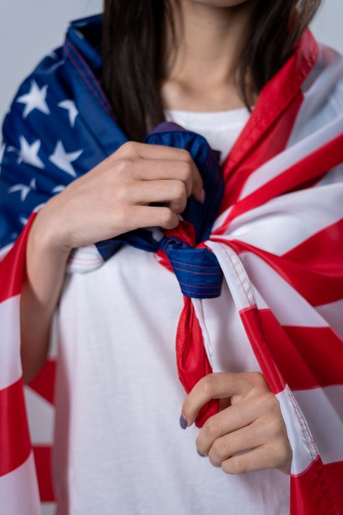 Free Close-up of a woman draped in an American flag, celebrating patriotism. Stock Photo