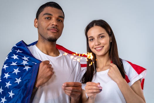 Couple celebrates Independence Day with a sparkler and American flag.