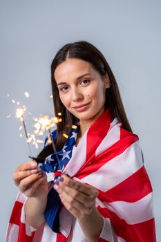 一名妇女举着美国国旗，燃放烟花庆祝国庆日