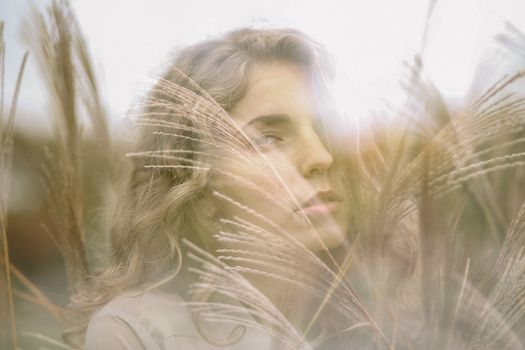梦幻般的女性肖像，描绘了一位被高草环绕、拥抱自然的女人