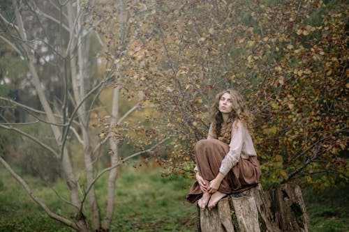Photo Of Woman Sitting On Wood