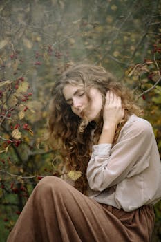 一位闭着双眼的女子，置身于点缀着红色浆果的秋叶之中，营造出宁静而梦幻的氛围