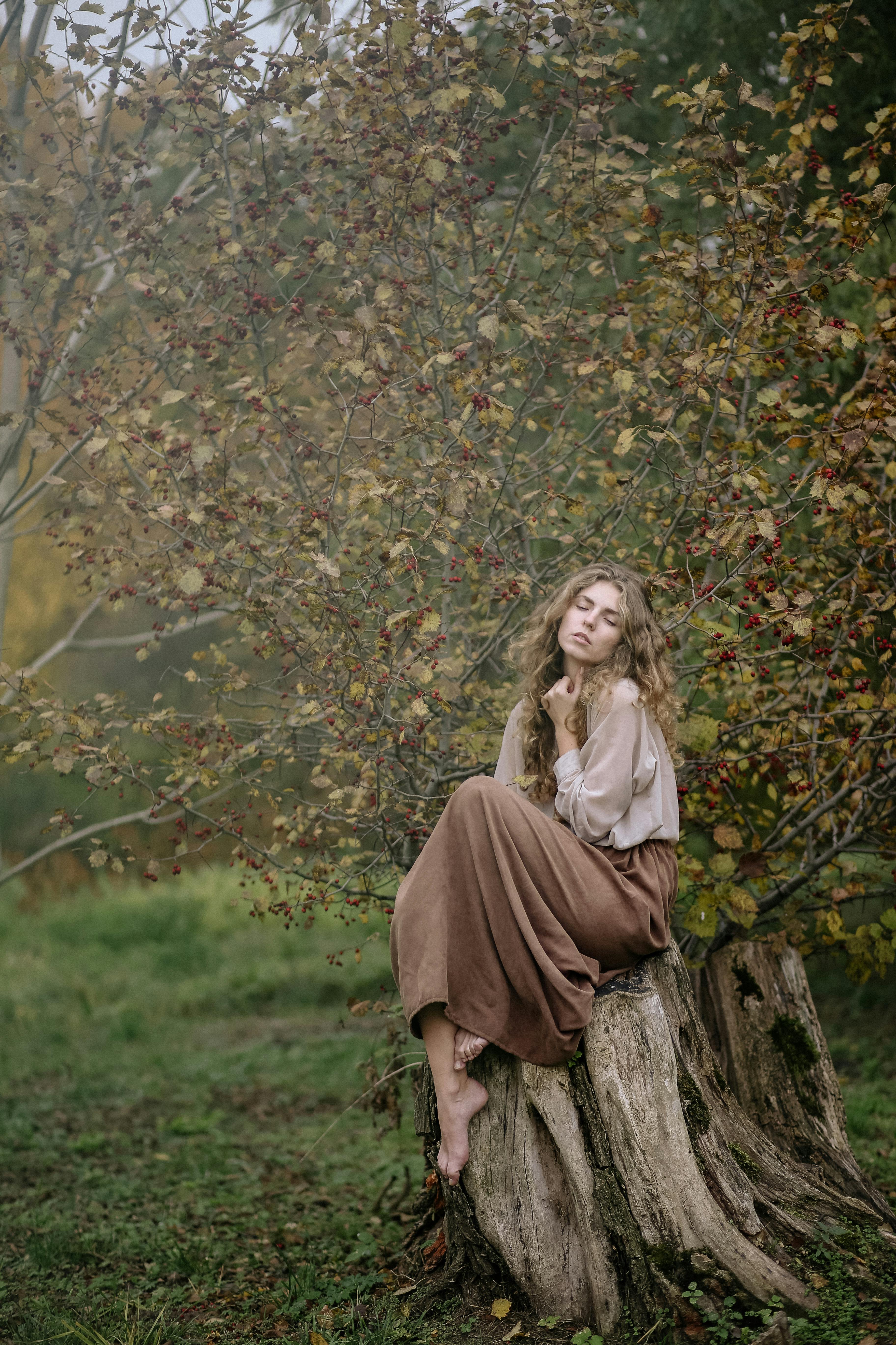 girl sitting against tree