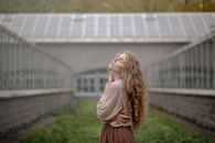 在柔和的灯光下，温室走廊里的女人安静地沉思
