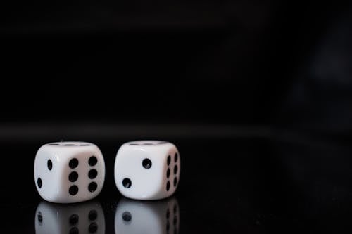 Free Close-up View Of Two White Dices on Black Surface Stock Photo