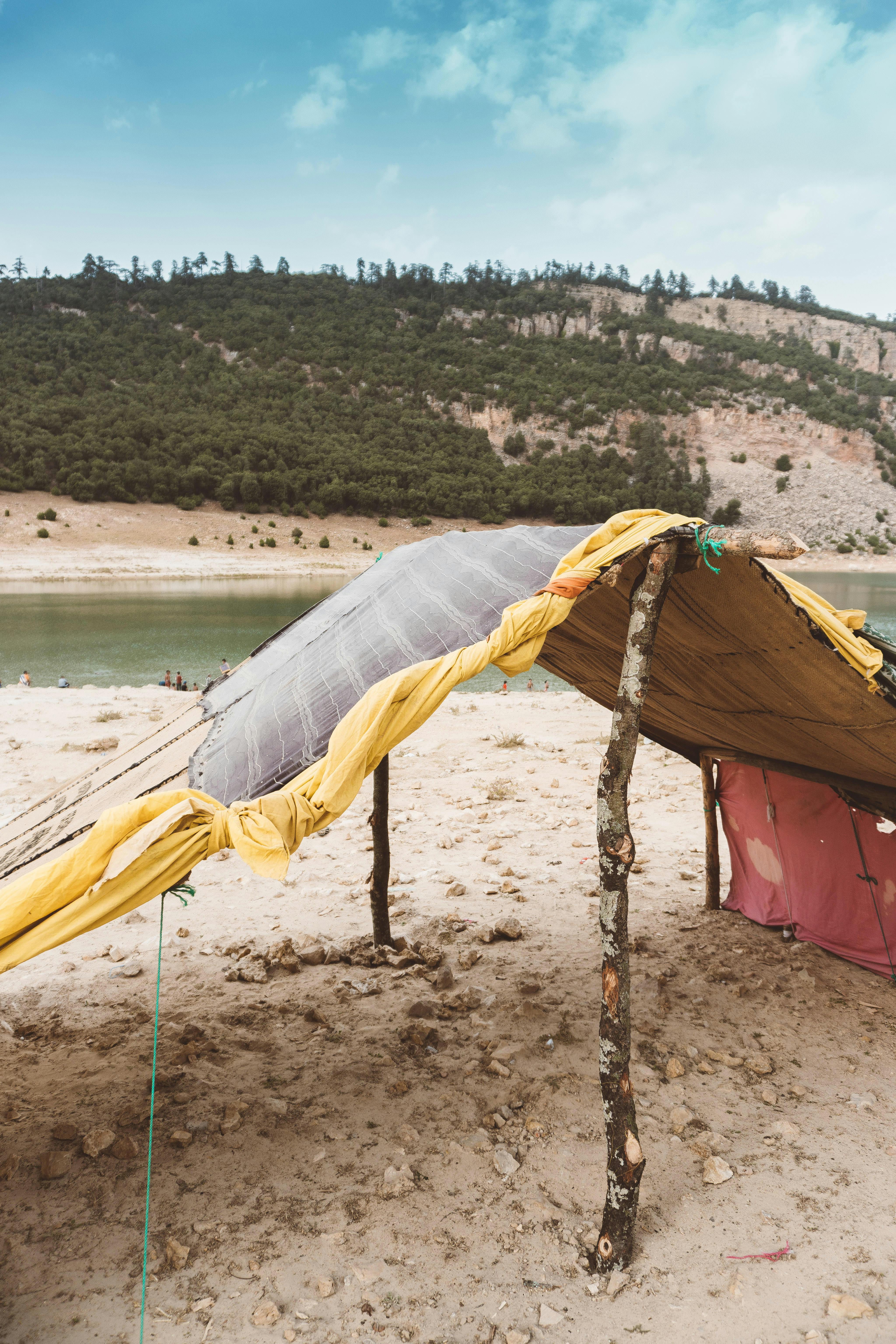 yellow and white tent near body of water