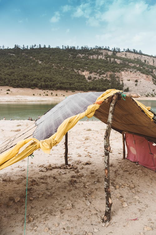 Free Yellow and White Tent Near Body of Water Stock Photo