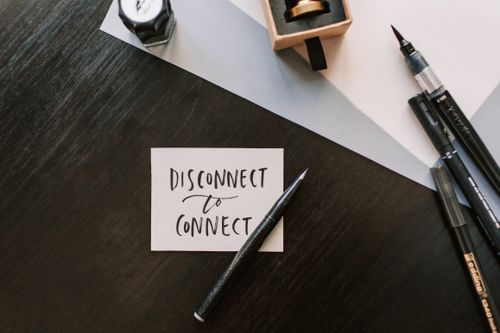 Handwritten note and brush pens on a wooden desk — photo by Vlada Karpovich on Pexels