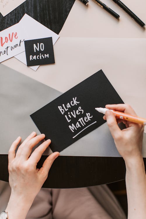 Free Person Writing Black Lives Matter on Black Paper Stock Photo