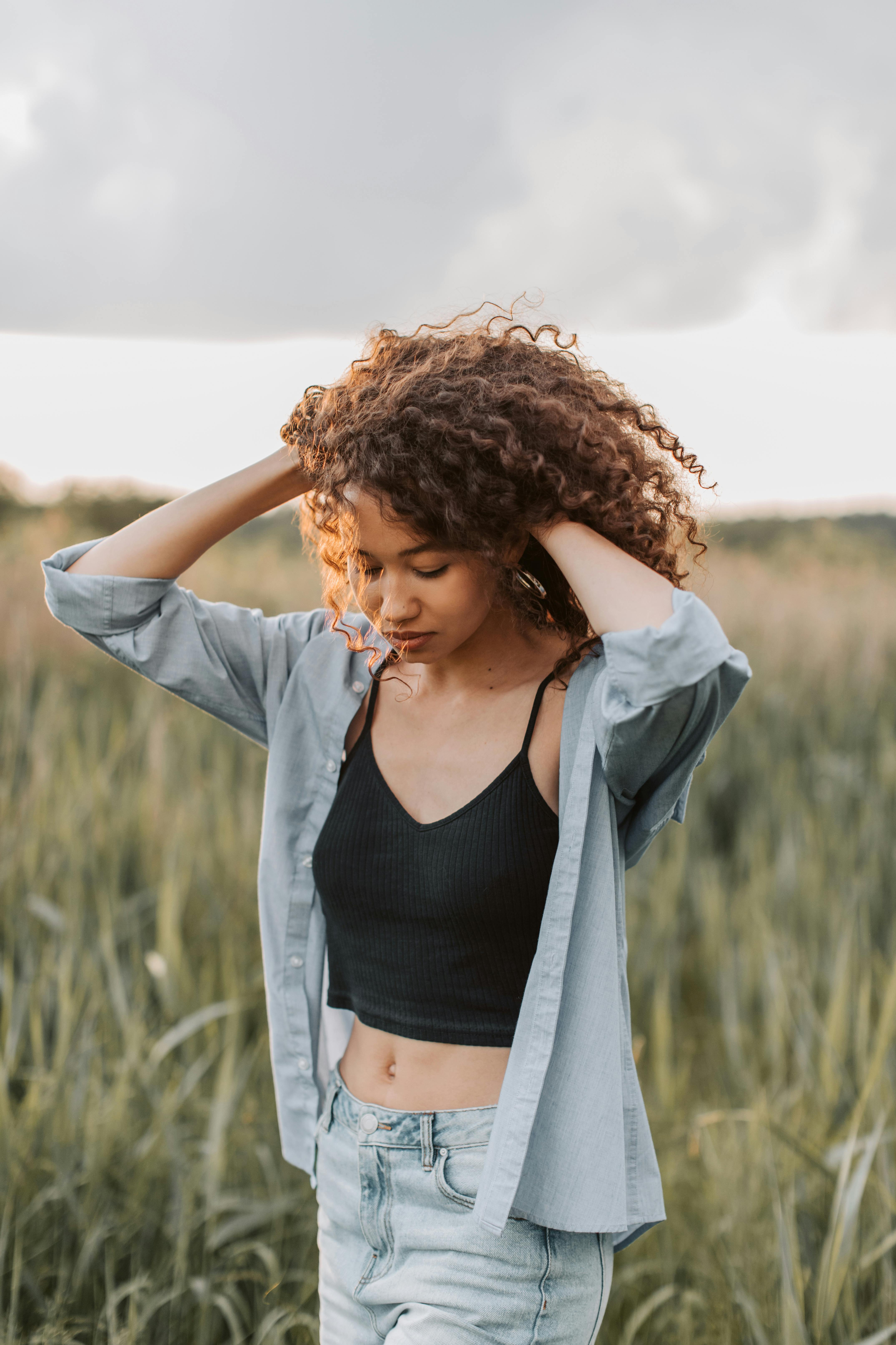 夜幕下的田野里，一位卷发的年轻女子优雅地摆出姿势