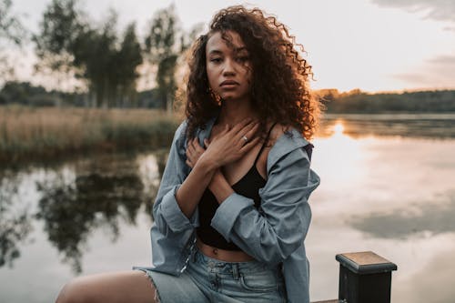 Photo Of Woman Sitting On Wooden Handrail