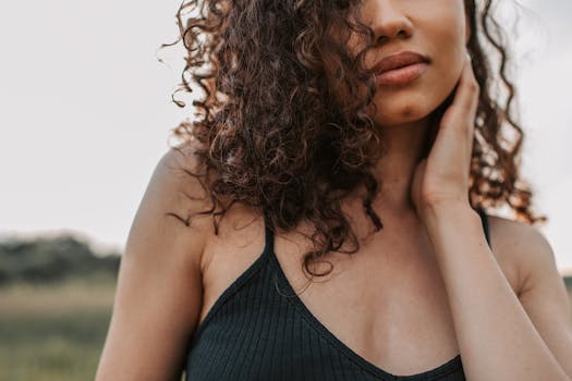 一位卷发时尚女性在宁静的户外环境中的肖像