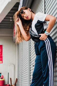 Stylish woman posing confidently in casual streetwear with sunglasses and headphones on.