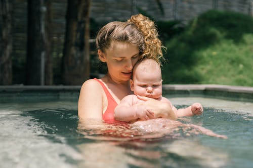 Free A Mother Carrying Her Baby while in a Swimming Pool Stock Photo