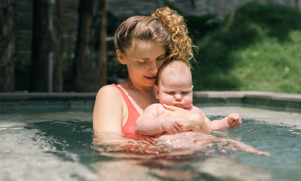 Mother holding baby in swimming pool