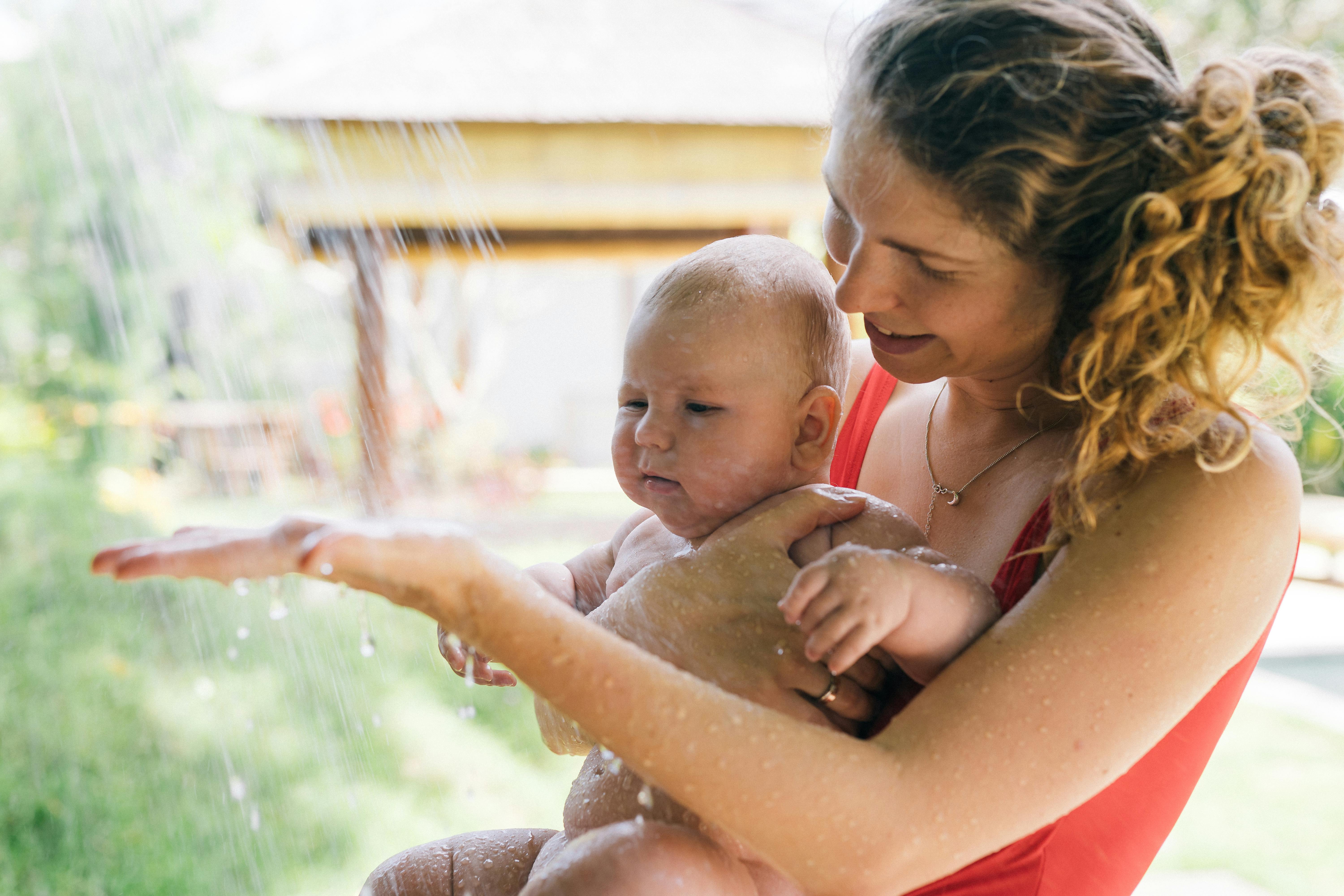 photo of woman carrying baby