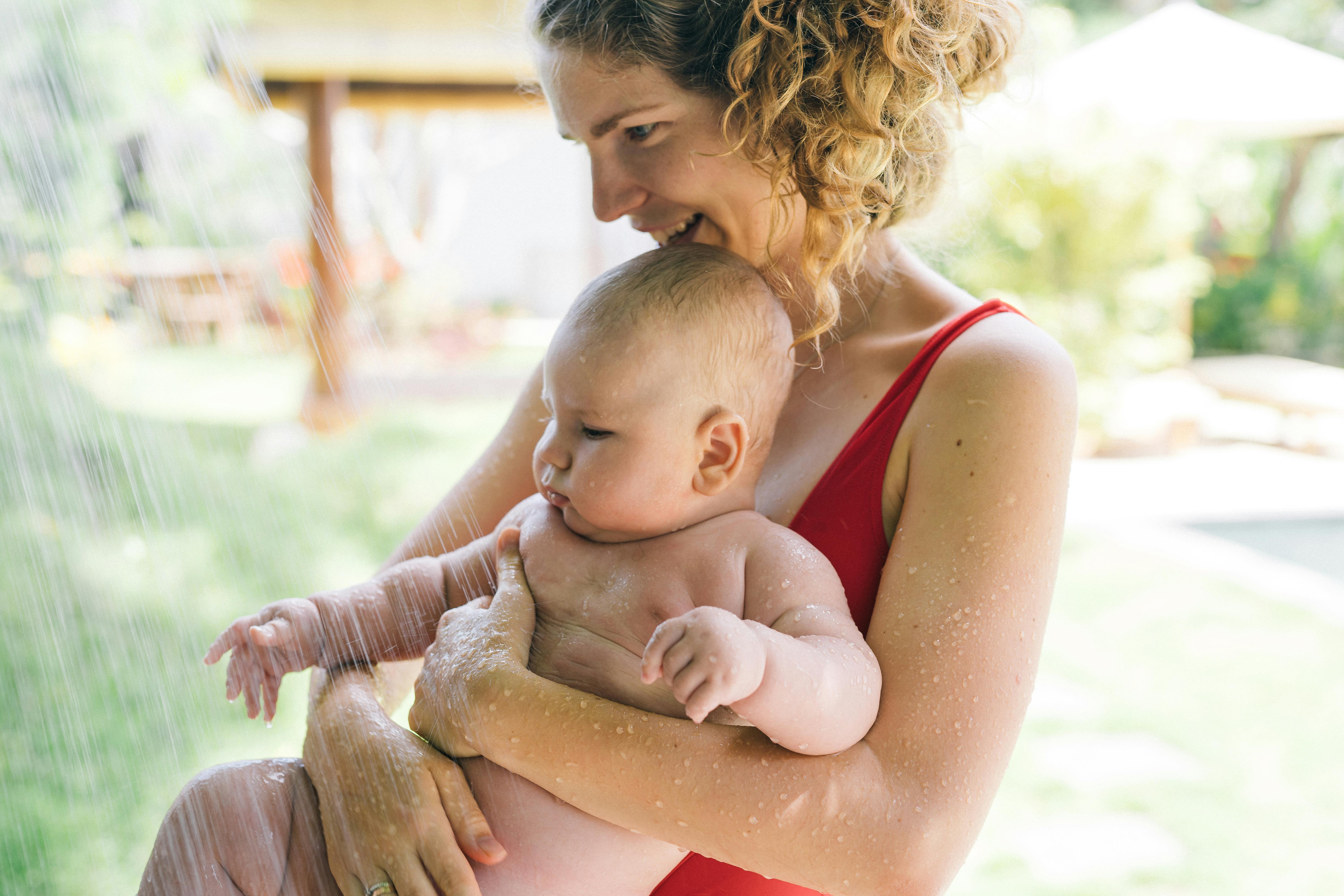 photo of woman carrying baby