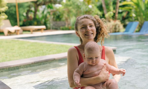 Baby swimming with parent in pool