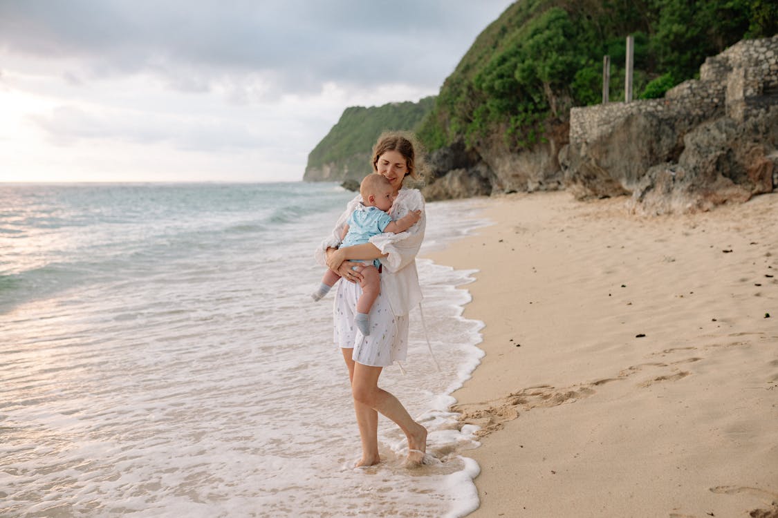 Mother Carrying Her Baby at the Beach