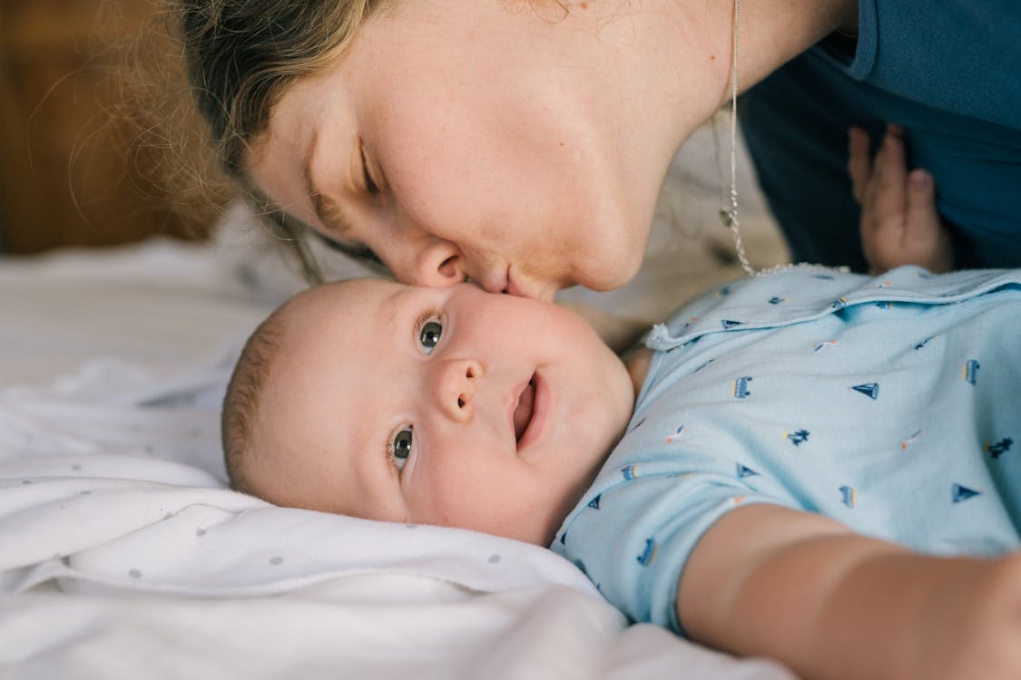 Free Photo Of Woman Kissing Baby Stock Photo