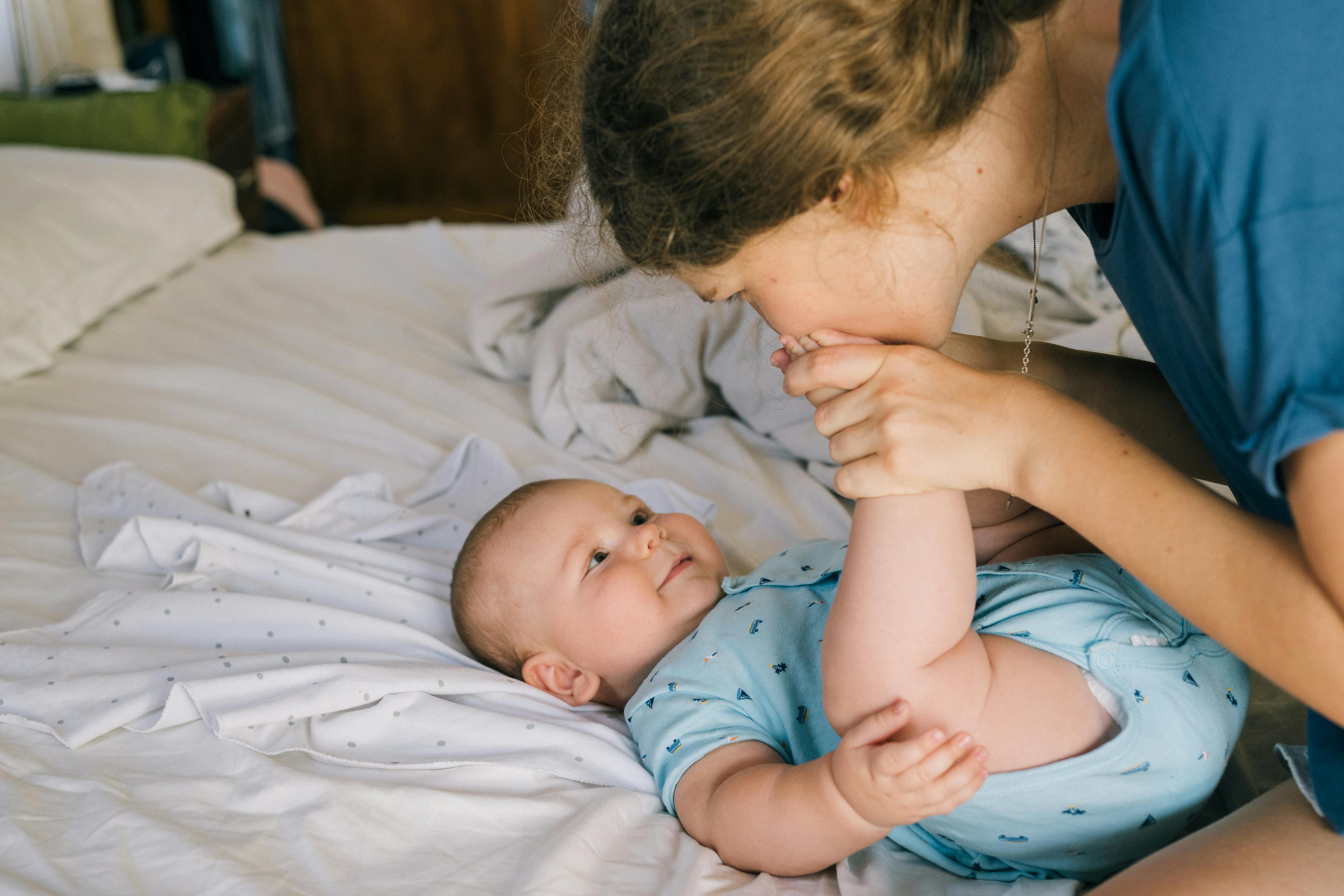 a mother kissing her baby s feet