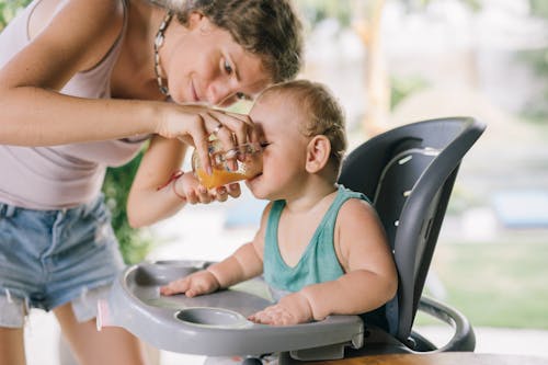 Free Woman Feeding a Baby Boy Stock Photo